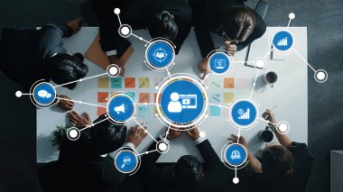 Çeşitli profesyoneller bir pazarlama stratejisi oturumuna katılıyor, verileri analiz ediyor ve modern ofis ortamında bir konferans masası etrafında yenilikçi fikirler paylaşıyor. Dostluk