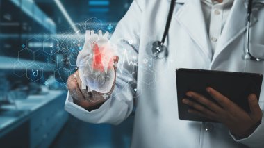 Tablet tutan yetenekli doktorlara yakın çekim yapın ve bulanık bir geçmişi olan kalp hologramına işaret edin. Tıp çalışanı teknolojiyi kullanarak tıbbi verileri kontrol ediyor ve analiz ediyor. İyileştirici.