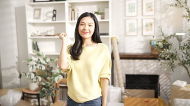 Anahtarı elinde tutan genç girişimci, merkez büroda dikilirken. Küçük işletmeleri yönetmek ya da başlamak için anahtarı taşırken kameraya özgüvenle bakan mutlu kadın satıcı. Myrmidon.