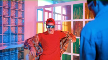 Kafkas dansçısı dans ederken çeşitli arkadaşları gece kulübünde neon ışıkta ayak seslerine bakıyor. Çoklu etnik kökenli hipsterin serbest stil müziğe geçişi ve mutlu bir adamın kameraya bakışıyla. Mutluluk.