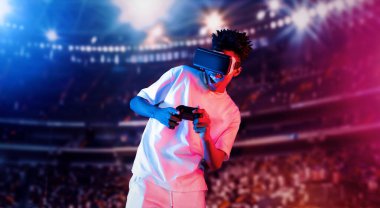 Yetişkinlerin elinde joystickle VR gözlükleri varken stadyumda arka planda bulanık oyunlar oynamaktan zevk alıyorlar. Afrikalı adam kontrol etmeyi ve artırılmış gerçeklik teknolojisini kullanmayı seviyor. Yaratıcılık.