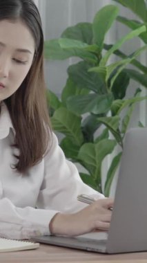 Ofiste çalışan ve dizüstü bilgisayar yazan hevesli bir iş kadını. Masasında oturmuş laptopla çalışan güzel bir ofis hanımı..