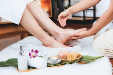 Adam lüks kaplıcalarda mutlu ayak masajına devam ederken, masör de hafif gün ışığı atmosferinde refleksoloji terapisi ya da otel ayak spa 'sında. Sessiz.