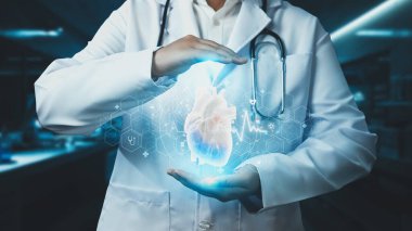 Hastanede kalp anatomisi hologramını tutan profesyonel doktorlara yakın çekim. Teknoloji yeniliklerini kullanarak kalp ameliyatına hazırlanan zeki bir tıp çalışanı. Kardiyoloji. İyileştirici.