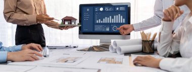 İç mimar tasarımcı grubu, daha kesin tasarım için planlar ve dizüstü bilgisayar ekran mimari yazılımı üzerinde birlikte tartışıyorlar. Modern ev tasarımı ve yenileme. İçgörü