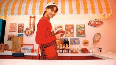 Profesyonel Asyalı restoran işçisi yemek hazırlar ve yemek barının arkasında durur. Kırmızı önlüklü çekici garson kameraya bakarken vişne topluyor. Çılgın dans. Mutluluk.