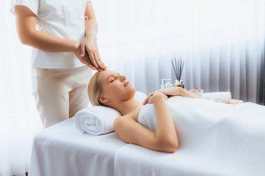Kafkasyalı kadın stres önleyici kafa masajından ve lüks tatil beldesi ya da otel spa salonundaki modern ışık ortamında yüz güzelliği eğlencelerini şımartmaktan hoşlanıyor. Sessiz.