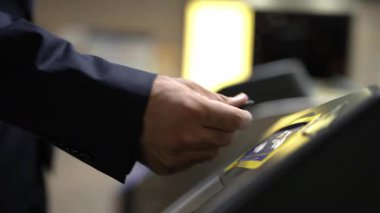Çok kültürlü yolcuların elleri turnikelerden geçerken gökyüzü treni, metro ya da insanlarla çevrili tüp gibi toplu taşıma araçlarını kullanarak madeni paraları tarar. Çalışma rutini. Sevinçli..