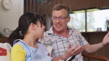 Büyükbaba ve torun birlikte TV 'de ilginç bir eğlence medyası izliyorlar. Eski üst düzey kullanım teknolojisi, genç nesil çapraz nesil ile iletişim kurarak aile bağlarını güçlendiriyor. Uyumsuzluk.