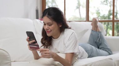 Kadın alışverişi ya da internet pazarında online ödeme modern yaşam tarzı için satılık eşyalar arıyor ve canlı siber güvenlik yazılımı tarafından korunan cüzdandan çevrimiçi ödeme için kredi kartı kullanıyor