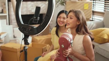 İnternette yayınlanırken gitar kılıfını gösteren ve satan mutlu bir çift. Çekici kız oturma odasında reklam ürünleri için online pazarlama kullanarak yayın yapıyor. Myrmidon.