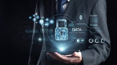 Bir işadamı, dijital bir kilit ve veri koruması ve siber güvenlik çözümlerini modern bir bağlamda vurgulayan bir arayüzü içeren bir akıllı telefonu güvenle elinde tutuyor. Dörtgen