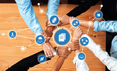 Bu görüntü, modern bir iş ortamında takım çalışmasının ve işbirliğinin özünü yakalıyor, kolektif çabayı ve yenilikçi stratejileri sembolize eden bir daire içinde el ele gösteriyor. Dostluk