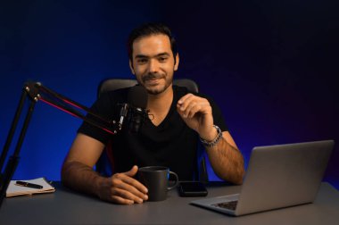 Yayıncı, fanclub dinleyicisiyle mikrofon kullanarak konuşuyor. Mor neon ışıklı modern stüdyoda yaratıcı olumlu düşünce konseptiyle canlı yayında finansal sorunları tartışıyor. Tahmin et..