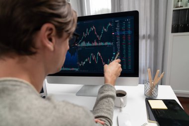 Akıllı yatırımcılar bilgisayar ekranlı ilginç borsa takasını işaret ediyorlar. Finansal teknoloji dinamik yatırım planı modern işyerindeki veri grafiğine odaklanıyor. Bireysel.