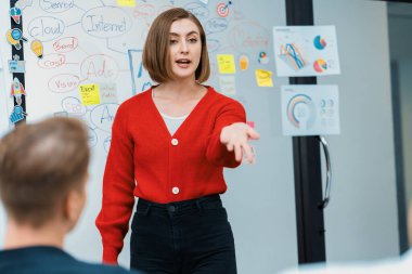 Profesyonel çekici kadın lider, modern iş toplantı odasında beyin fırtınası zihin haritalama istatistikleri ve renkli yapışkan notlar kullanarak yaratıcı pazarlama planını sunuyor. Tertemiz..