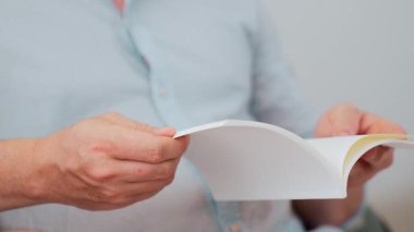 Kanepede oturan erkek, meslek büyümesi için ürün sunmak ya da iş değerini akıllı iş adamı olarak en yüksek noktaya çıkarmak için yaşam tarzı ve bilgi konseptine sahip bir defter ya da kitap hazırlar. Uyumsuzluk.
