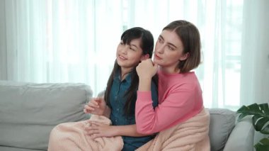 Annesi peri masalı anlatırken, mutlu kız beyaz annelerin kucağında oturuyor. Anne, kızı eve bakıp gülümserken ona sıcak bir şekilde sarılıyor. Aile birlikte vakit geçirir. Pedagoji.