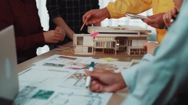 Çeşitli bir ekip, mimari tasarımlar, planlar ve prototipler üzerinde odaklanmış, modern ve yenilikçi bir çalışma alanı sunan ortak bir toplantıya katılıyor. SACTR