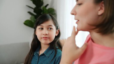 Mutlu anne oturma odasında otururken kızıyla deneyim paylaşıyor. Kafkas anne ve mutlu çocuk konuşuyorlar ve birlikte vakit geçiriyorlar. Çekici kız gülümserken ebeveyn hikayesini dinler. Pedagoji.