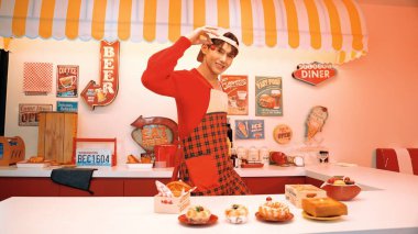 Profesyonel Asyalı restoran işçisi yemek hazırlar ve yemek barının arkasında durur. Kırmızı önlüklü çekici garson kameraya bakarken vişne topluyor. Çılgın dans. Mutluluk.