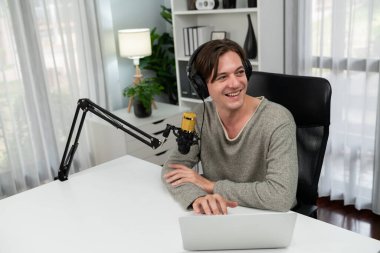 Sunucu kanalı, gülümseyen akıllı yayıncı kaydı, senaryosu ve akıllı telefonuyla sosyal medyada sohbet programı, kulaklık takarak modern ev stüdyosundaki video flamalarını kaydediyor. Bireysel.