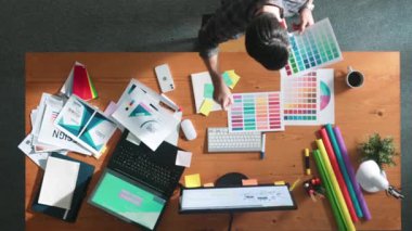 Kulaklıktan müzik dinlerken yetenekli iç dizayn grafiklerinin yukarıdan aşağı havadan görüntüsü. Proje yöneticisi kulaklıkla çalışırken ve rahat şarkılar dinlerken stüdyoda hareket ediyor. Sempozyum.