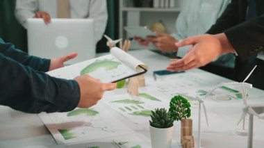 Bir grup iş adamı, yenilikçi fikirler alışverişinde bulunarak ve çağdaş bir ofis ortamında büyüme tablolarını analiz ederek ortak bir toplantı düzenliyor. SACTR