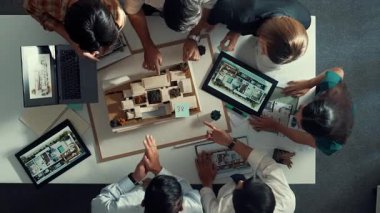 Yöneticinin ev modelini göstermesi ve bina tasarımını açıklaması. Tablet ev planı sergilenirken iç yapı hakkında beyin fırtınası yapan mimar mühendisinin hava görüntüsü. Hizalama.