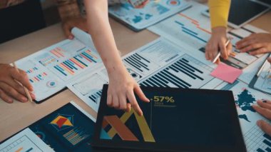 Çeşitli bir ekip, modern bir ofiste yapılan strateji toplantısında veri içgörülerini, grafikleri ve grafikleri tartışır. İşbirliği etkili karar verme mekanizması sağlar. SACTR