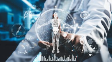 Yetenekli doktorların oturduğu ve insan anatomisi hologramına işaret ettiği yakın çekim. İnsan vücuduna HUD gösterge paneli kullanarak erişip tıbbi verilerle bağlantı kuran bir tıp çalışanı. İyileştirici.