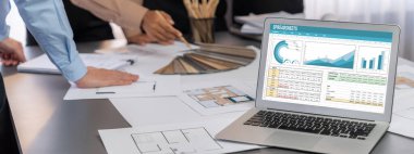 İç mimar tasarımcı grubu, daha kesin tasarım için planlar ve dizüstü bilgisayar ekran mimari yazılımı üzerinde birlikte tartışıyorlar. Modern ev tasarımı ve yenileme. İçgörü