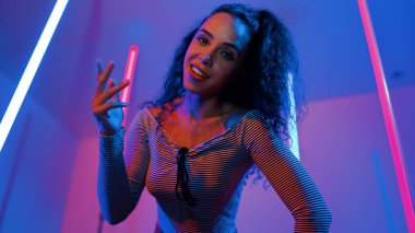 Latin dansçıların kameraya bakıp şehrin pop müziğiyle dans ettiği düşük açılı kamera. Profesyonel çekici hipster, mor veya neon ışıklı hip hop şarkısına geçiyor. Şık bir kumaş. Mutluluk.