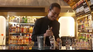 Asyalı barmenin karışık kokteyl likörünü likör karışımına katması, özel reklamı yaratıcı, canlandırıcı, bar lüksünde canlandırıcı bir vitrin haline getiriyor. Vinosity.