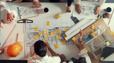 Yetenekli mühendis takımının ev modelini ölçerken konuştuğu tepeden tırnağa görüntü. Birlikte çalışan ve mühendislik inşaatı için plan yapan bir grup akıllı iç mimar. Hizalama.