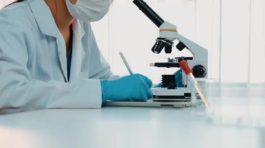 Laboratuvar kimya araştırmacısı mikroskop kullanarak yeni ilaç ya da tedavi geliştirir. Laboratuvar mikrobiyoloji ekipmanları ile bilimsel uzmanlık ile sağlık hizmetlerinin teknolojik gelişimi. Ağır çekim. Katı.