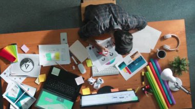 Toplantıda tasarımcı yazma ve logo grafiği tasarlamanın en üst görünümü. Renkli paletler üzerinde çalışan iş adamlarının yakınlaşması ve masaya kağıt ve ekipman ile yapışkan notlar yazmak. Sempozyum.