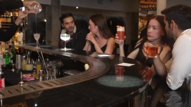 Paloma, Margarita, Old Fashioned ve Martini 'de arkadaşlarıyla sohbet ederken, barmen de özel parti kokteylleri hazırlarken. Vinosity.