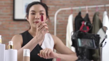 Kadın nüfuzlu kişi canlı yayın yapan video görüntülerini sosyal medya ya da blog üzerinden gözden geçiriyor. Kozmetik stüdyosu ışıklandırmalı mutlu genç kız çevrimiçi pazarlama oturumu yayını için..