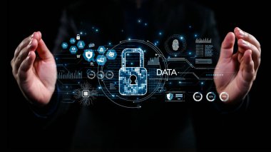 Bir iş adamı, teknolojideki veri güvenliğini vurgulayarak, kilit sembolü etrafındaki koruyucu el hareketleri yoluyla dijital güvenliğin önemini gösteriyor. Dörtgen