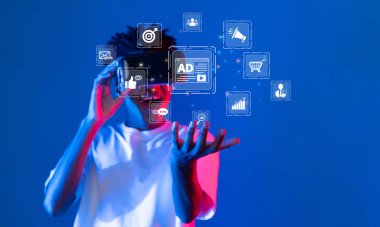 Genç bir birey, çevrimiçi pazarlama ve iletişim araçlarını temsil eden canlı simgelerle çevrili dijital reklam kavramları sergileyen bir akıllı telefon ile meşgul oluyor. XDMCP