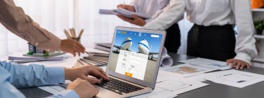 İç mimar tasarımcı grubu, daha kesin tasarım için planlar ve dizüstü bilgisayar ekran mimari yazılımı üzerinde birlikte tartışıyorlar. Modern ev tasarımı ve yenileme. İçgörü