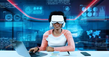 Masada ödev yaparken yapay zeka kullanarak metaevreleri birbirine bağlayan dizüstü bilgisayar ve artırılmış gözlük kullanan bir kız. Öğrenci holograma bakıyor ve bulanık ofiste oturuyor. Yaratıcılık.