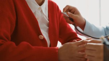 Hasta klinikte ya da hastane ofisinde doktor randevusuna gidiyor. Hastaların nabzını steteskopla kontrol edip risk faktörünü belirleyen doktor semptomları inceliyor. Panorama. Katı.