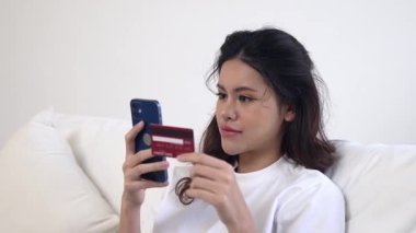 Kadın alışverişi ya da internet pazarında online ödeme modern yaşam tarzı için satılık eşyalar arıyor ve canlı siber güvenlik yazılımı tarafından korunan cüzdandan çevrimiçi ödeme için kredi kartı kullanıyor