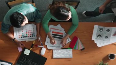 Zeki insanların kağıt fırlatıp finansal dökümanlar ve etrafa dağılmış borsa analiz kağıtlarıyla toplantı masasında beşlik çakması. Ekibin hava görüntüsü projeyi kutluyor. Sempozyum.