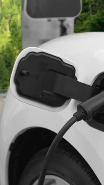 Tepe yolundaki şarj istasyonunda elektrikli arabanın çevresel farkındalığı için yenilikçi bir kavram. EV araba temiz çevre için yenilenebilir enerjiden güç alıyor.