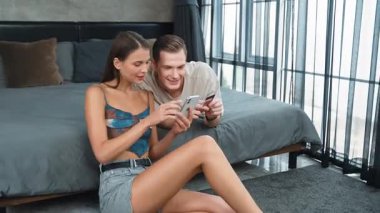 Genç çift, online ödeme uygulaması ve dijital cüzdanı kullanarak kredi kartıyla ödeme yaptıktan sonra mutlu ve heyecanlı hissediyorlar. Mobil internet üzerinden alışveriş ve modern alımlar. Düzenle