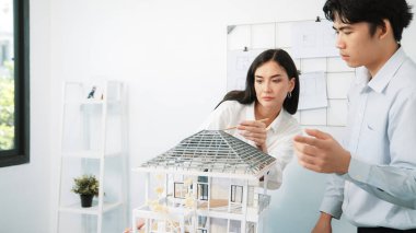 Modern ofisteki ev modeli yapısını kontrol etmeye odaklanan genç, profesyonel mimar mühendis ekibine yakın çekim. Yaratıcı profesyonel tasarım ve takım çalışması konsepti. Tertemiz..