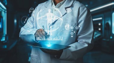 Kalemi insan anatomisi hologramıyla gösterirken akıllı doktorun tableti tutmasına yakın durun. HUD gösterge panelini ve teşhis belirtilerini incelemek için teknolojiyi kullanan bir tıp çalışanı. Teknoloji. İyileştirici.